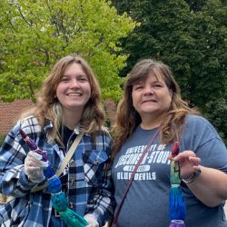 Katy and her mom holding tie-dyed shirts